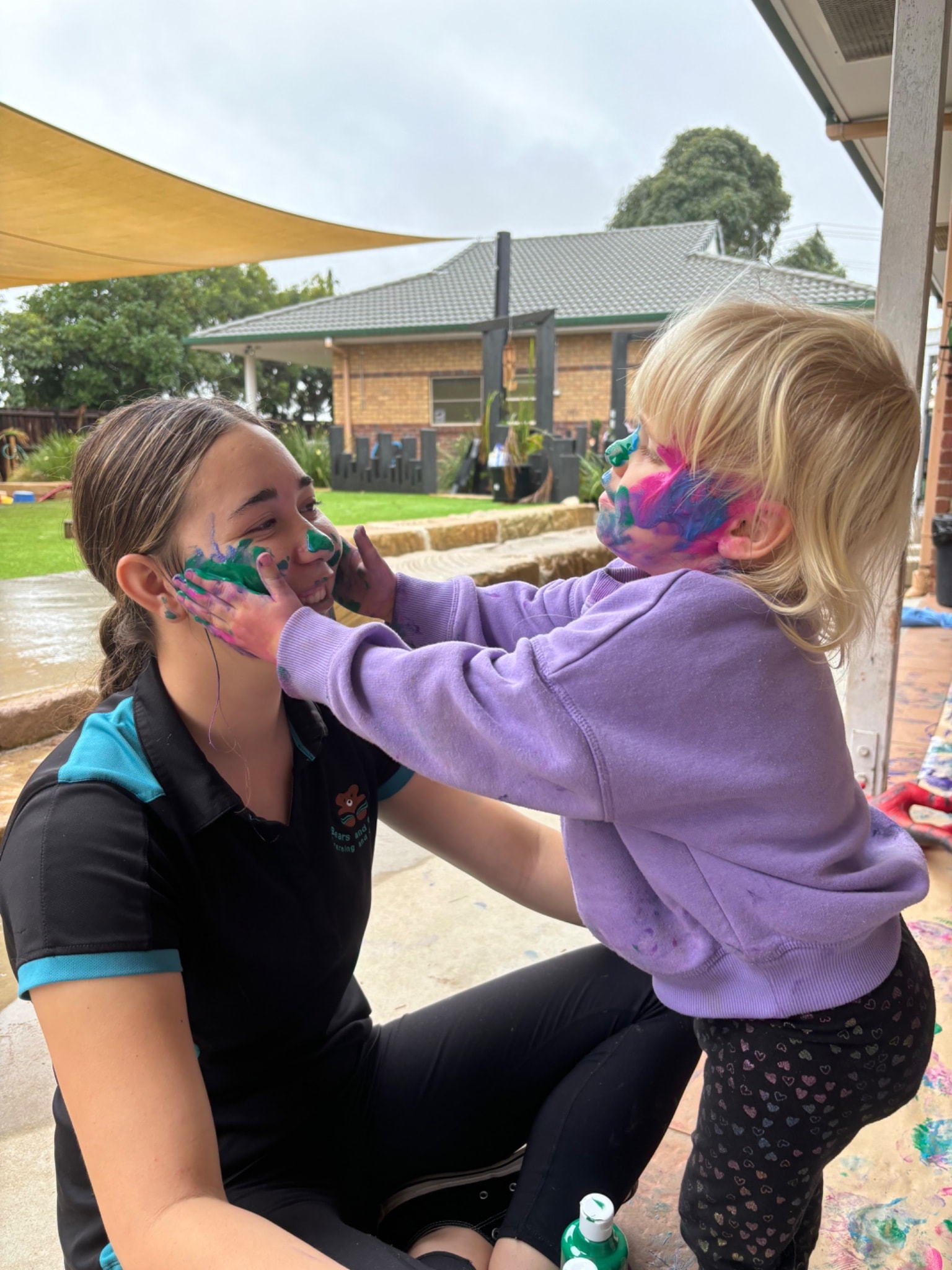 child_painting_educators_face