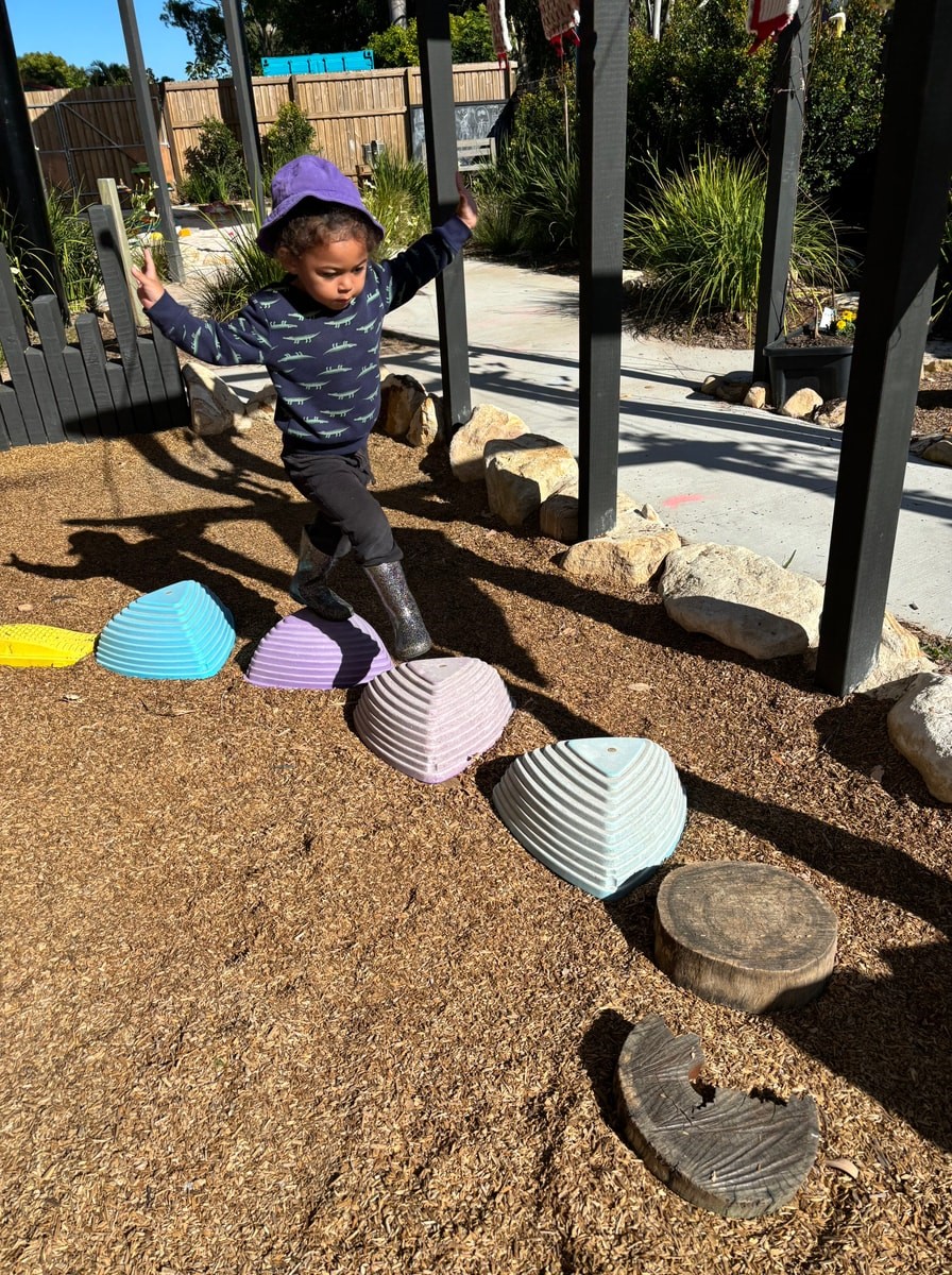 child_on_stepping_stones